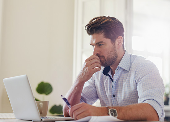 Pracovník hledí do notebooku a snaží se vymyslet nejlepší způsob pro řešení problémů měst